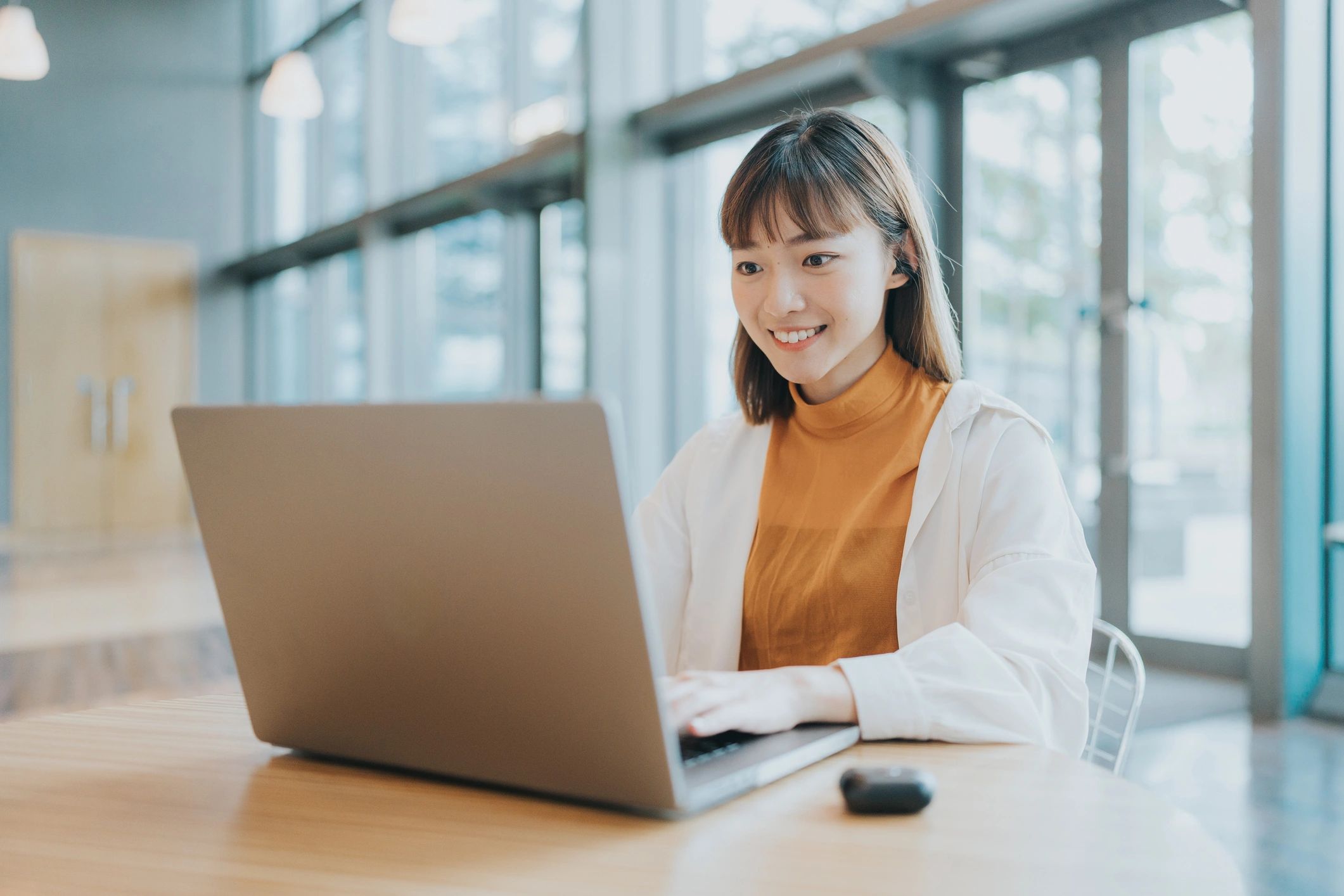 Virtual assistant working on a laptop in a bright workspace